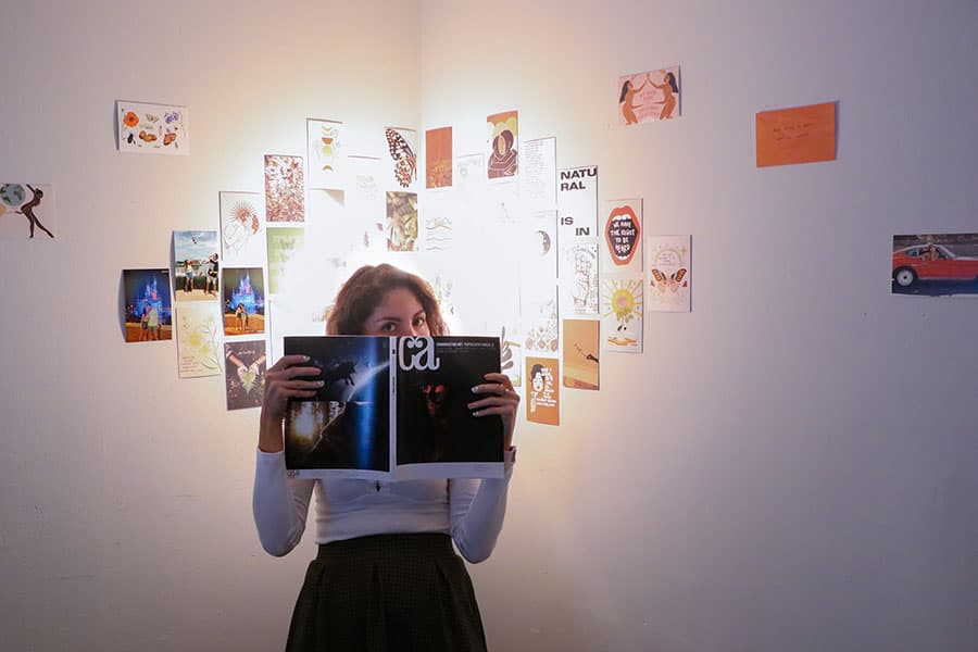 Celsius graphic designer Romina Combe reading the Communication Arts journal in her decorated office.
