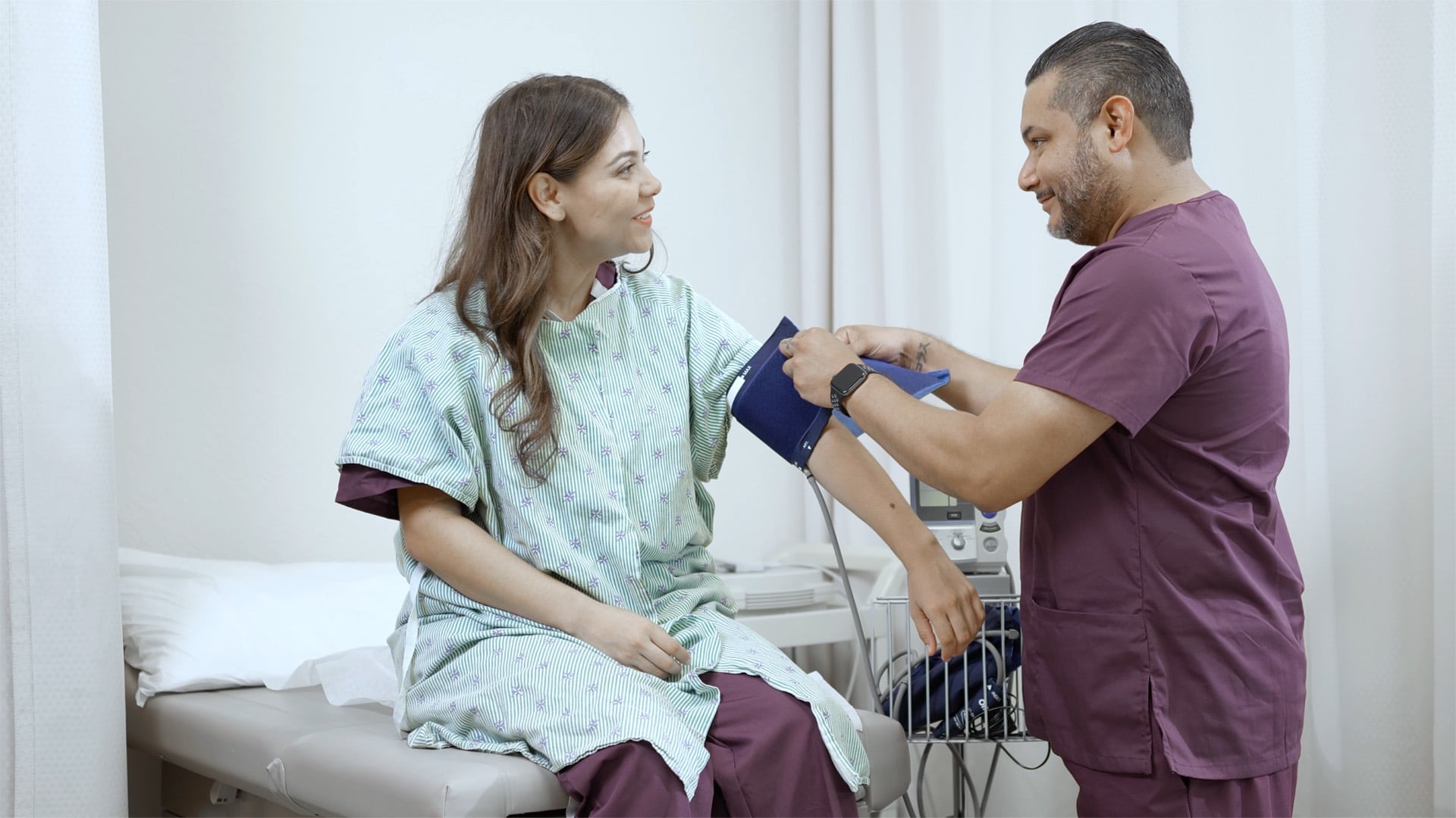 Medical assisting student placing blood pressure cuff on partner's arm