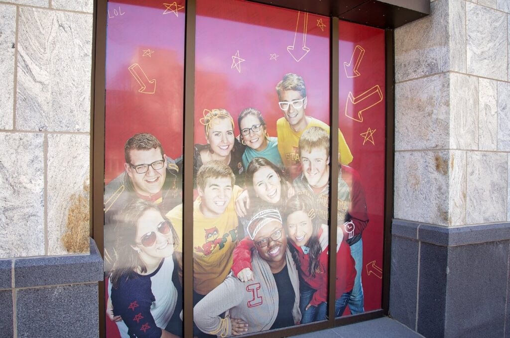 Window graphics designed for the ISU College of Agriculture and Life Sciences building, featuring a student of photos overlaid with hand-drawn iconography.
