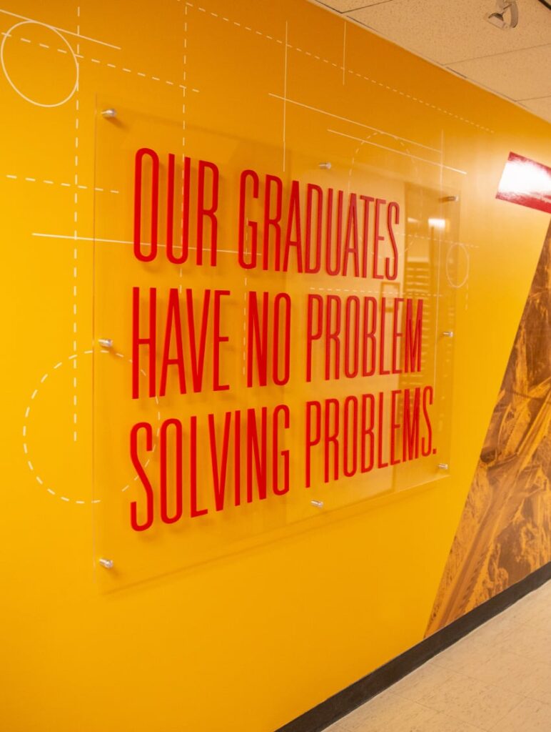 Environmental design for ISU's Department of Civil, Construction and Environmental Engineering, featuring wall graphics and an acrylic standoff declaring, "Our graduates have no problem solving problems."