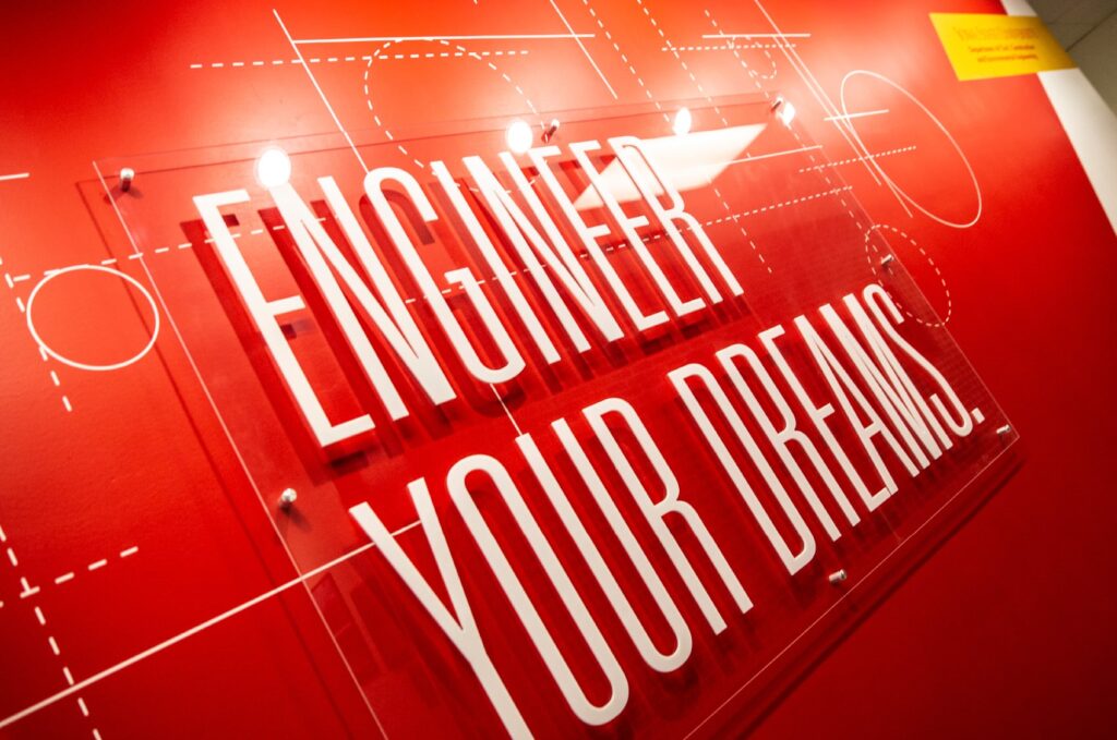 Key artwork for ISU's Department of Civil, Construction and Environmental Engineering, featuring wall graphics and an acrylic standoff with typography declaring, "Engineer you dreams."
