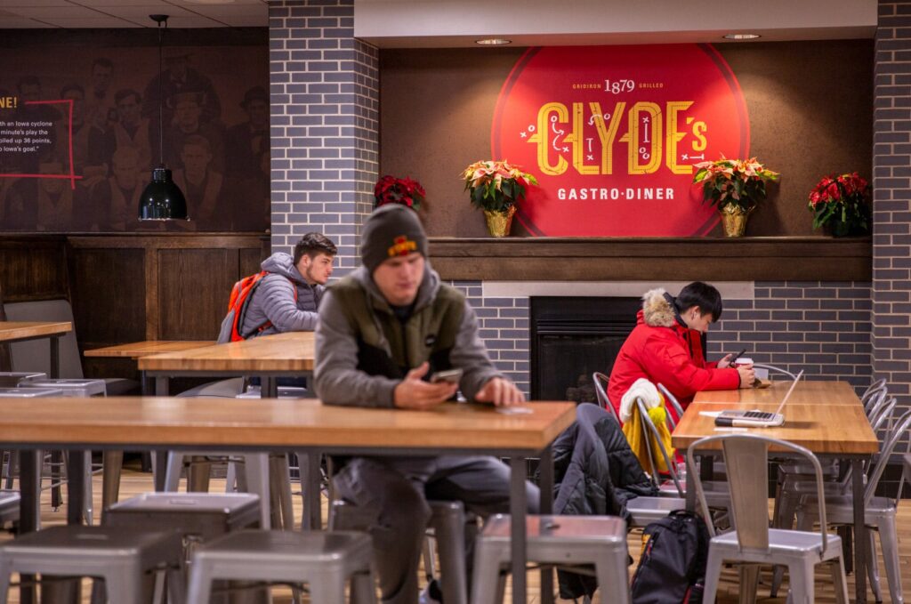 Restaurant design for Clyde's Gastro Diner, featuring wall graphics and customer seating.