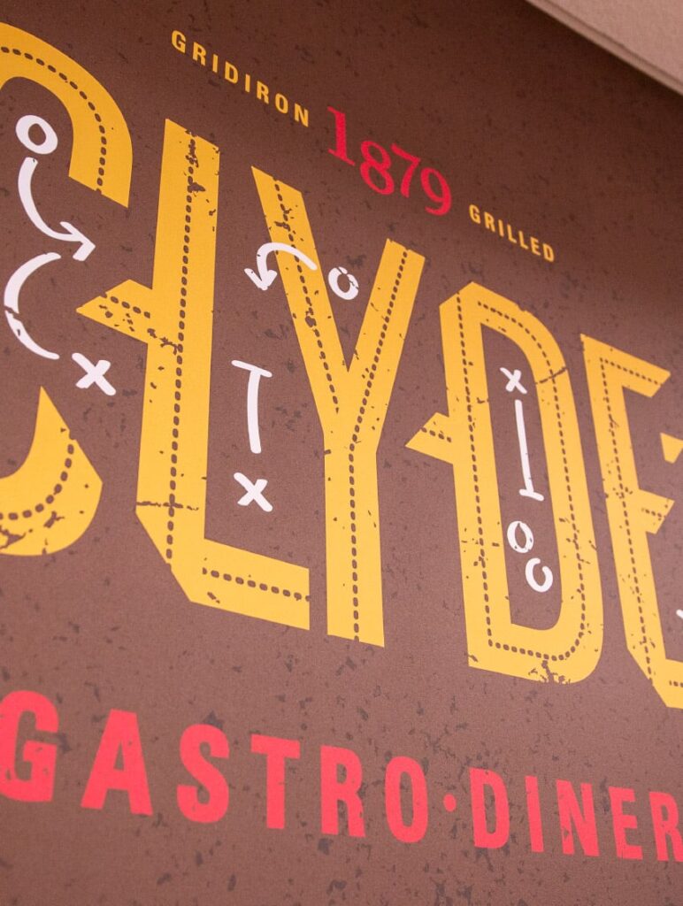 Close-up photo of Clyde's Gastro Diner's logo, featuring intricate details between the letters.