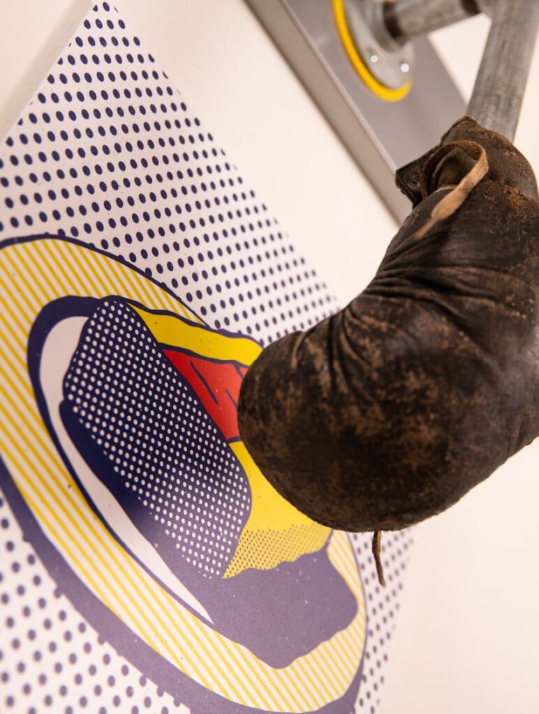 Detail of the boxing glove art installation in the Flying Hippo office, with a glove pointed down punching a halftone graphic.