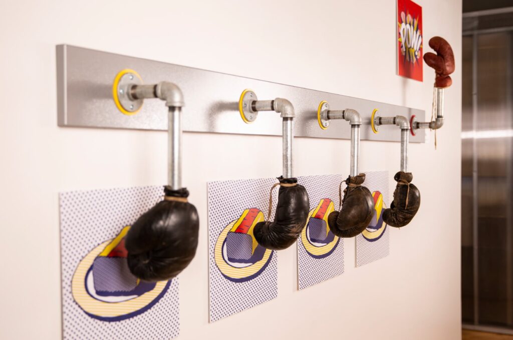 Art installation in the Flying Hippo office, featuring boxing gloves affixed to pipes.