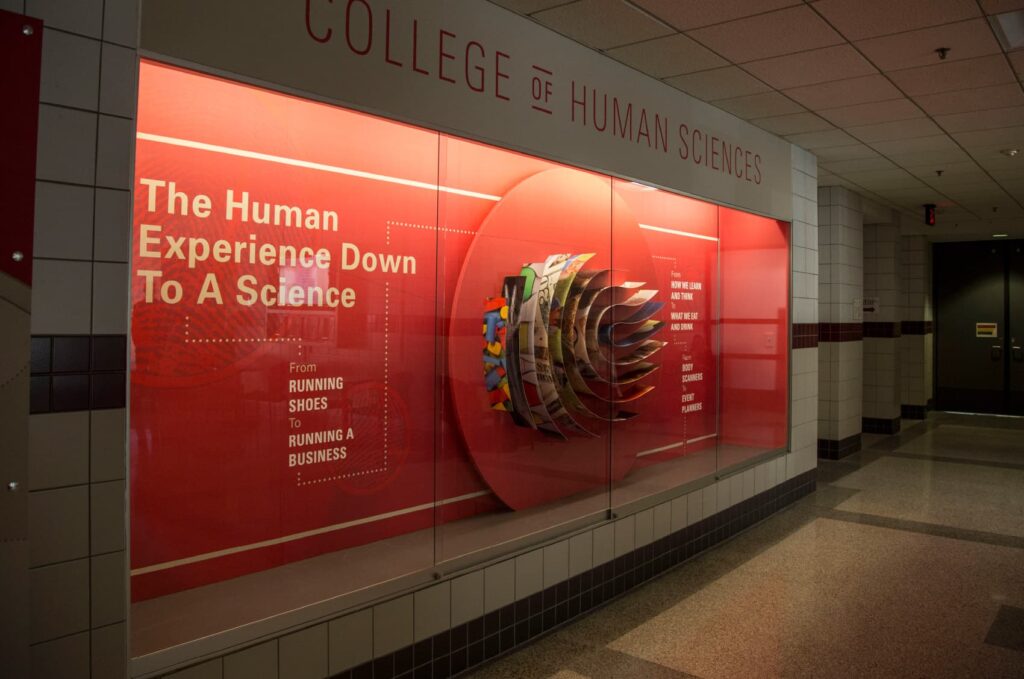 Photo of ISU's College of Human Sciences' custom art installation, featuring strips of humanitarian photography quilled into a fingerprint design.