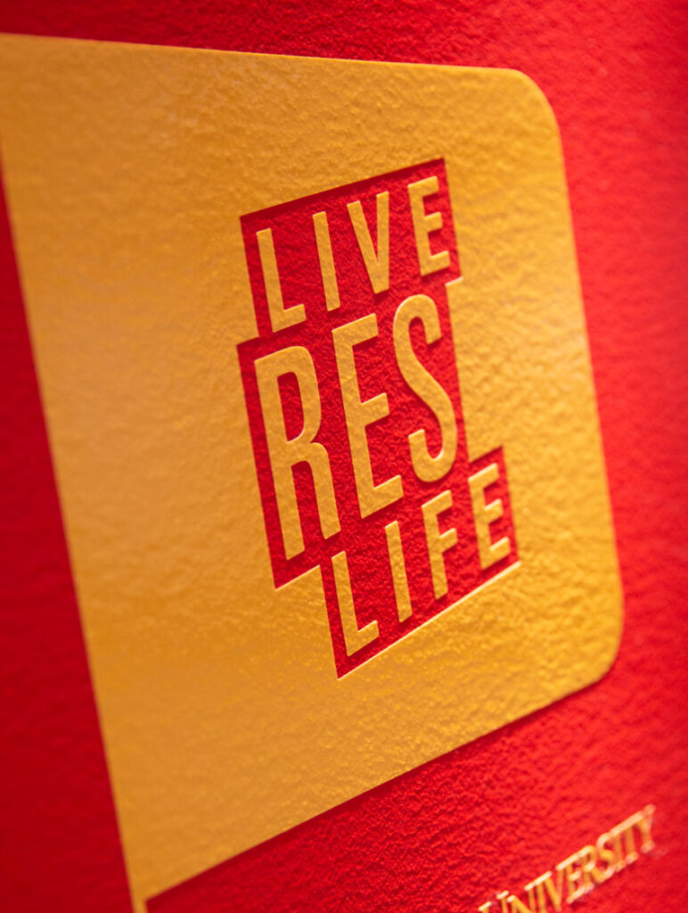Detail of a wall graphic in The Mezzanine on ISU's campus, declaring in fun typography to, "Live res life."