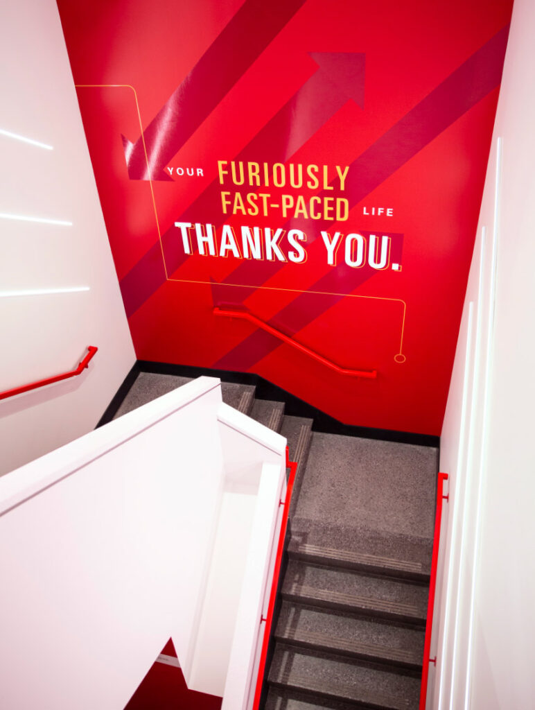 Environmental design in the stairwell leading up to The Mezzanine on ISU's campus, with bold typography declaring, "Your furiously fast-paced life thanks you."