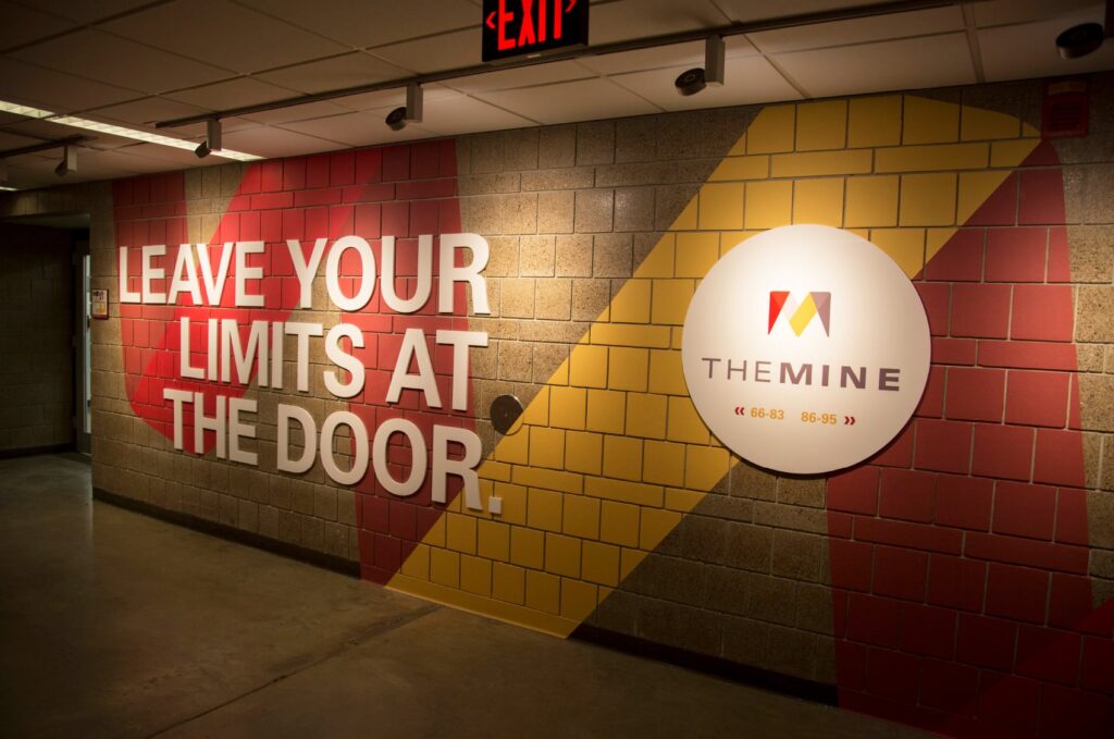 Directional signage for The Mine, ISU's basement labs in the Department of Mechanical Engineering. 3D letters declare, "Leave your limits at the door."