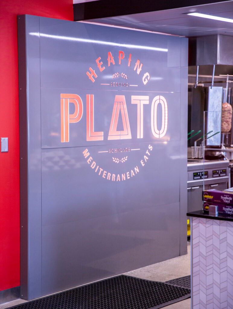 The Heaping Plato logo printed behind the cashier.
