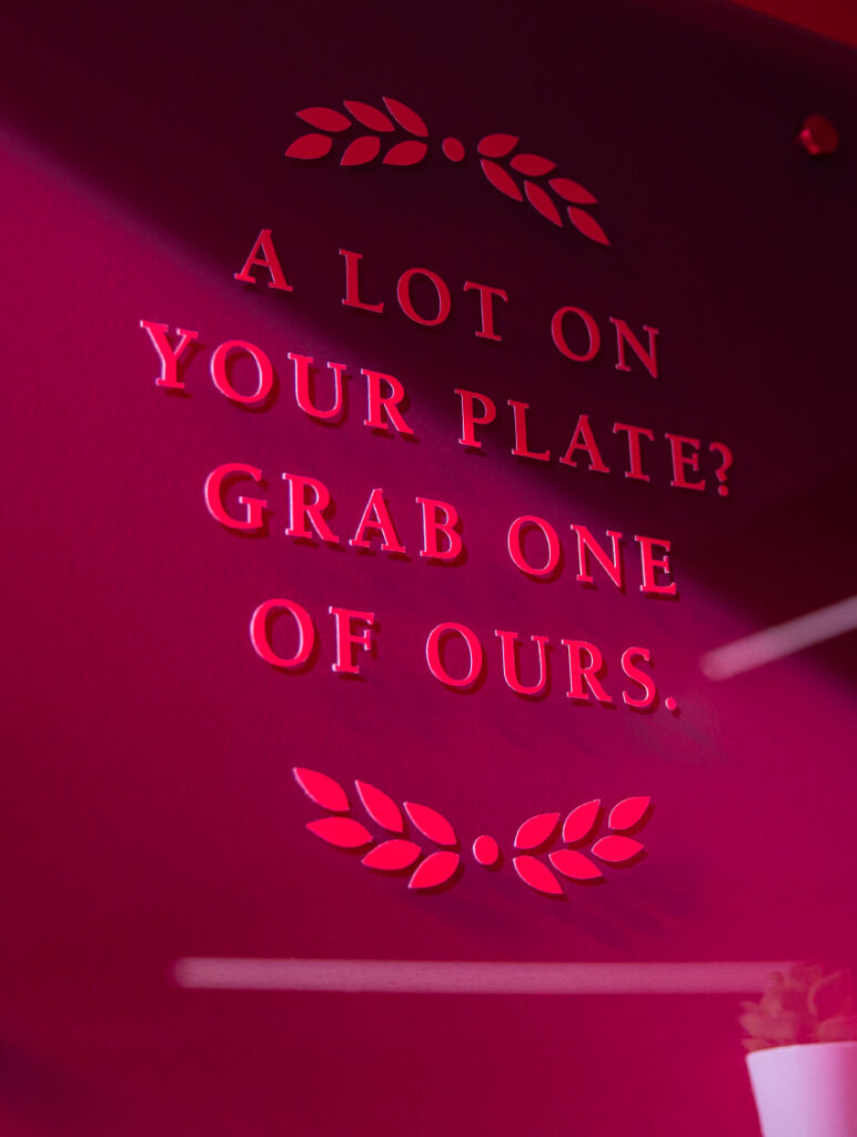 Detail of a wall graphic at Heaping Plato, with typography declaring, "A lot on your plate? Grab one of ours."