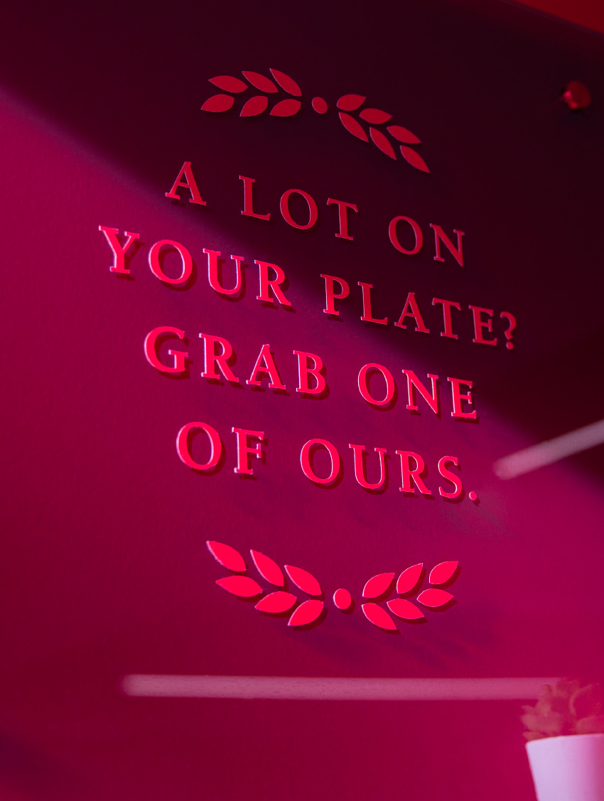 Detail of a wall graphic at Heaping Plato, with typography declaring, "A lot on your plate? Grab one of ours."