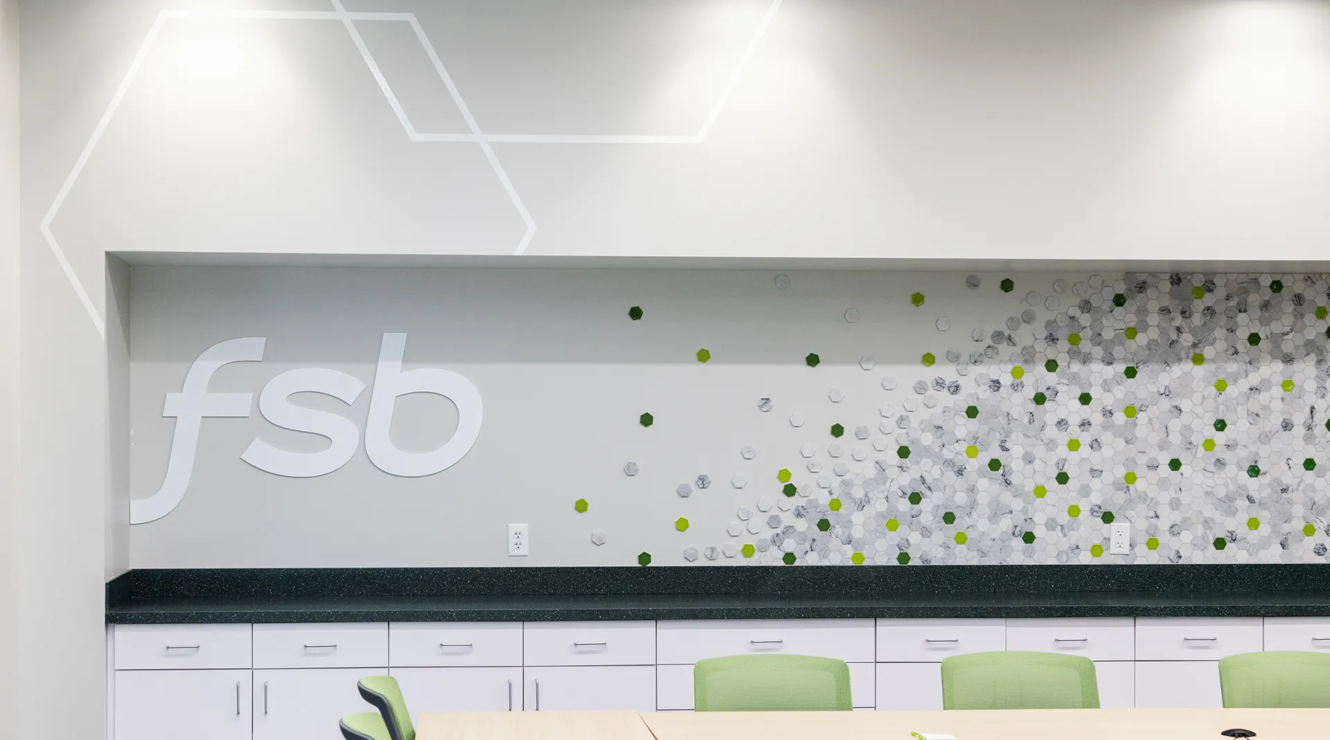 Backsplash installation featuring hexagon tiles and the FSB logo in acrylic lettering at the Farmer's State Bank Des Moines branch's break room.