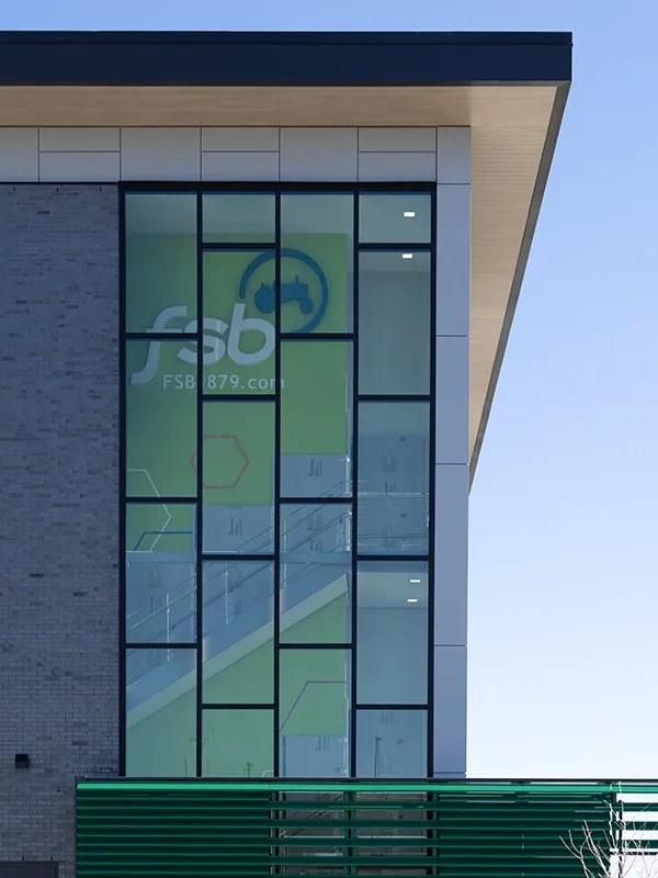 The Farmer's State Bank logo installed with 3D acrylic in the Des Moines branch's building stairwell, as seen from outside at street level.