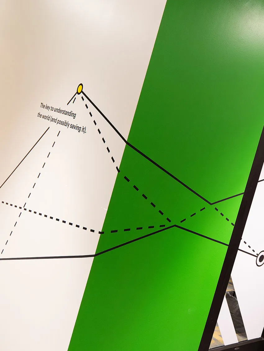 Abstract wall art with geometric lines and green panels, featuring a thought-provoking caption about understanding the world.