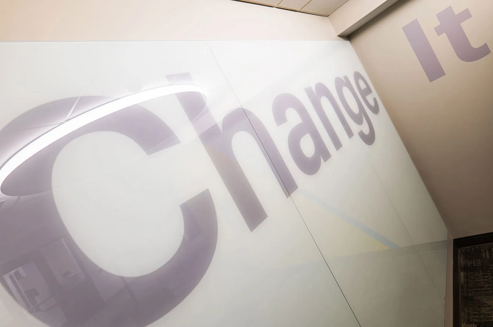 Modern office wall with Change It in oversized text, reflecting a motivation for innovation and transformation.